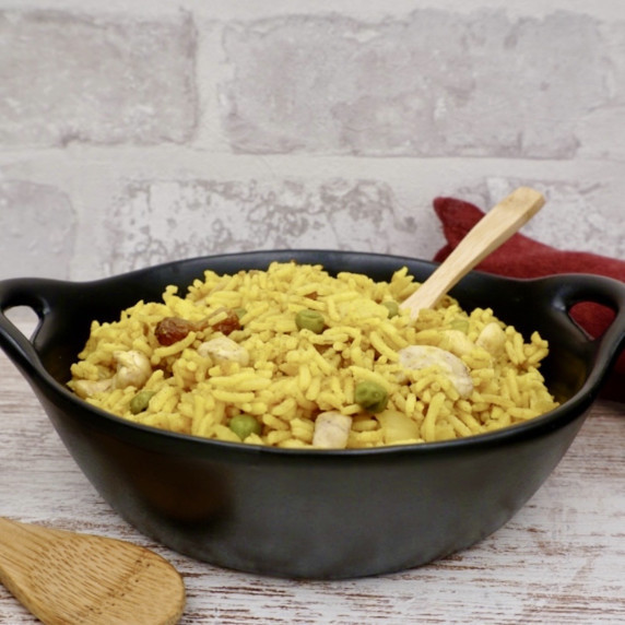 Fragrant pilau rice in a white serving bowl on a table mat