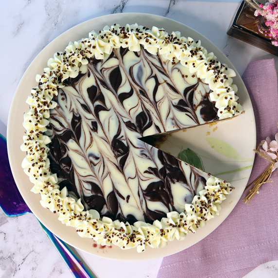 Dark chocolate caramel macaroon tart on a plate with a single slice missing.