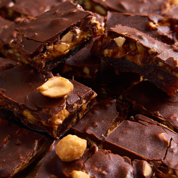 A stack of Date Peanut Chocolate Bark, showing the layers of dates, peanut butter and chocolate.