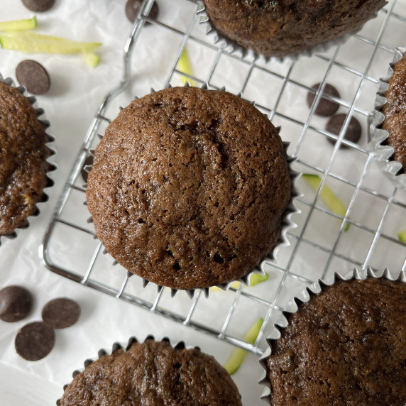 Chocolate zucchini muffins on a wire cooling rack.