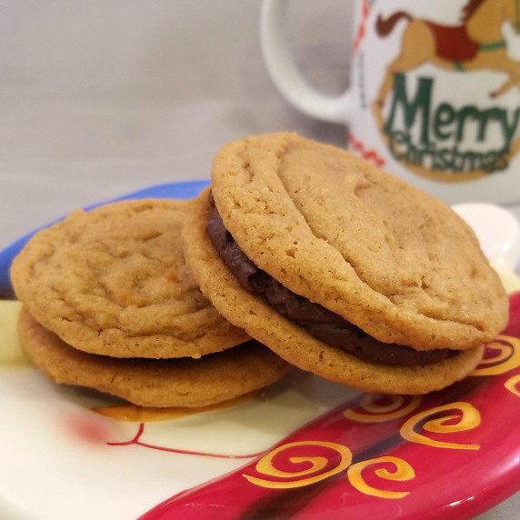 Dulce de Leche Duo cookies on a holiday plate with a holiday mug in the background