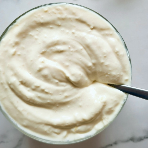 Creamy Garlic Sauce in a bowl with a spoon in it.