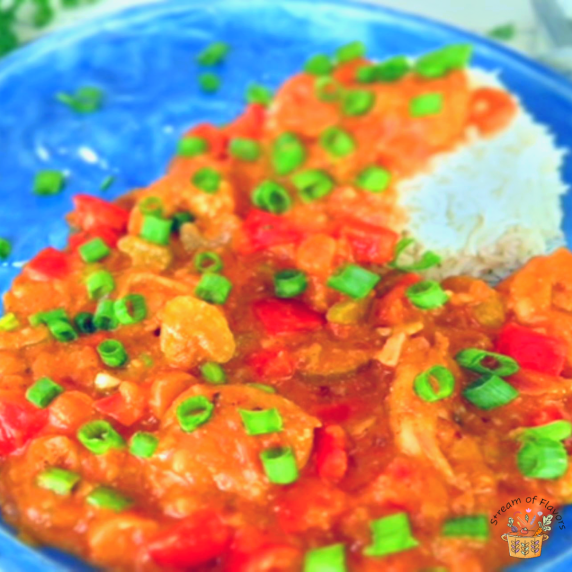 Easy Shrimp Creole with aromatics, onions, tomatoes, carrots, celery, and shrimp on a blue plate