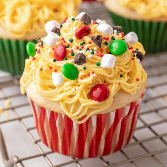 Cupcake with yellow frosting made to look like spaghetti topped with various candies & marshmallows.