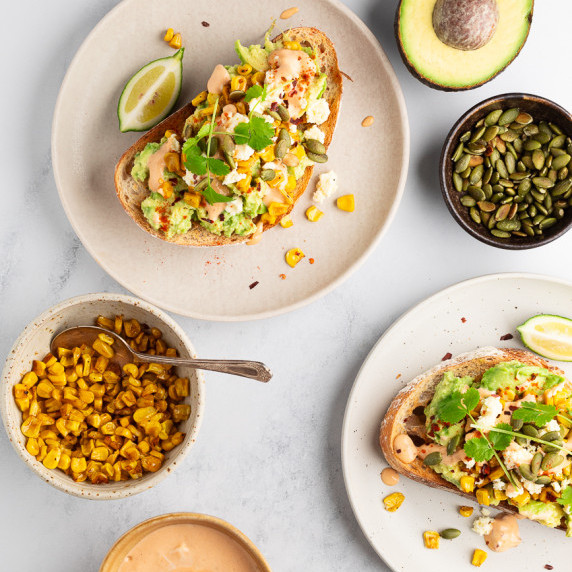 Avocado and corn toast arranged on plates on a table