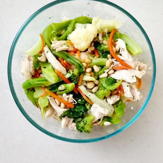 chicken tossed with steamed vegetables, topped with toasted pine nuts