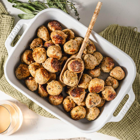 A baking dish filled with golden brown turkey meatballs.