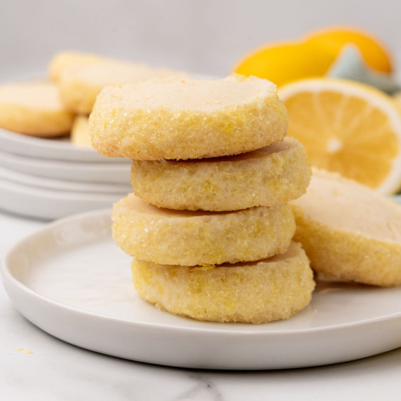 A stack of lemon shortbread cookies on a white plate.