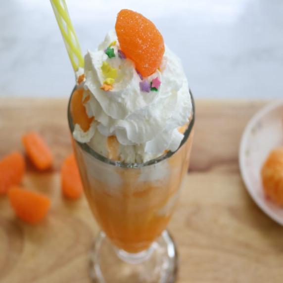 Orange Float with whipped cream, sprinkles, and a gummy orange