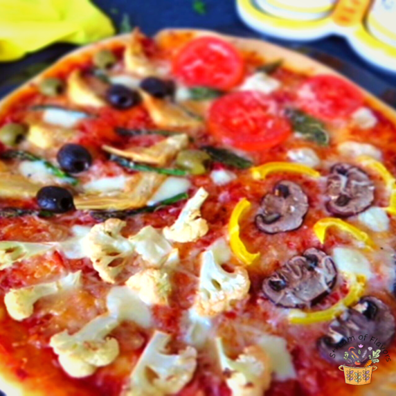Four seasons pizza with asparagus, artichoke, basil, tomato, olive, mushroom, pepper and cauliflower
