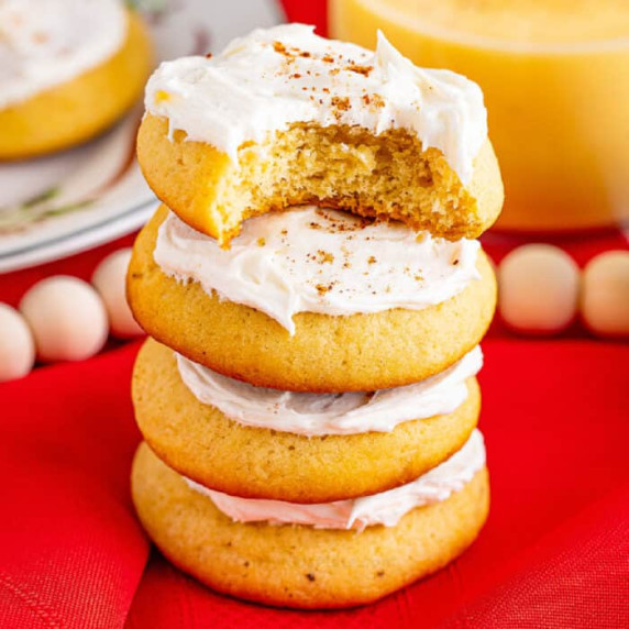 Four Frosted Eggnog Cookies Stacked with bite out of top cookie
