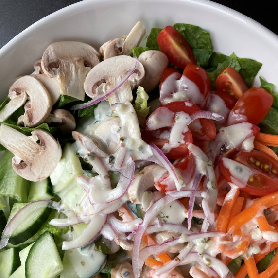 Salad with romaine, mushrooms, cucumbers, tomatoes, carrot and onion with a creamy dressing.