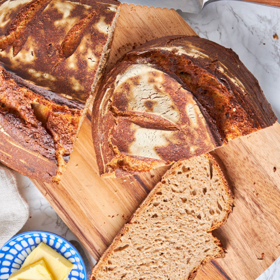 German Sourdough Protein Rye Bread on a board, cut open, one slice in front