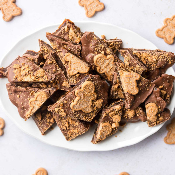 Gingerbread Christmas Crack Date Bark Pieces on white plate with gingerbread men around