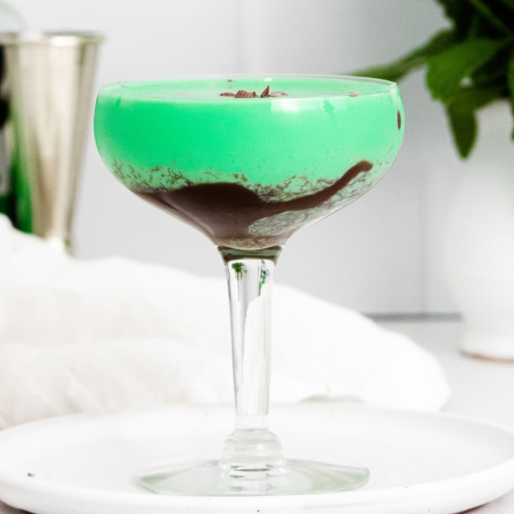 bright green creamy cocktail with chocolate swirled on bottom of the glass and chocolate shavings on