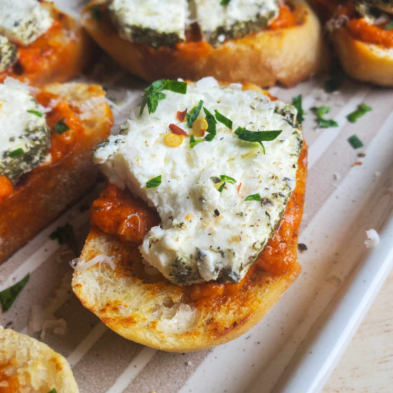 Golden crostini topped with red pesto and white goat's cheese.