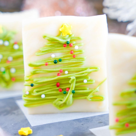Vanilla fudge piece decorated with green chocolate and sprinkles like a Christmas tree.