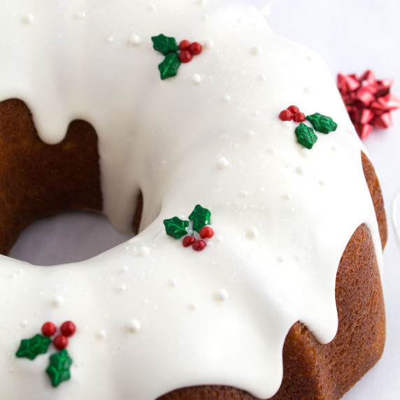 Bundt cake decorated with holly and berry sprinkles.