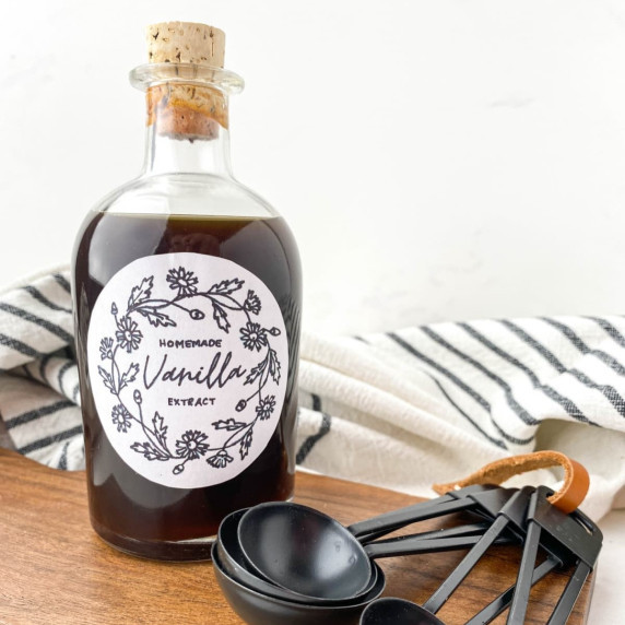 bottle of homemade vanilla extract with measuring spoons nearby