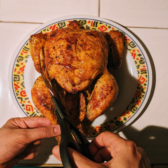 carving a roast chicken with kitchen scissors