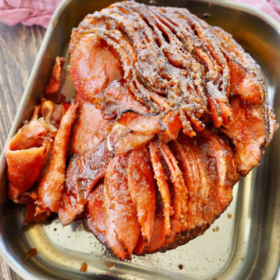 A juicy, honey baked spiral sliced ham in a roasting pan, ready to eat. 
