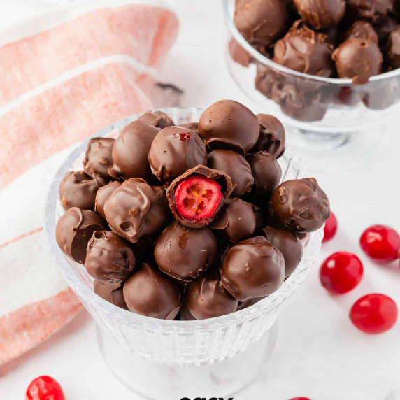 Chocolate-covered cranberries in glass bowls on top of countertop, a few cranberries on the surface