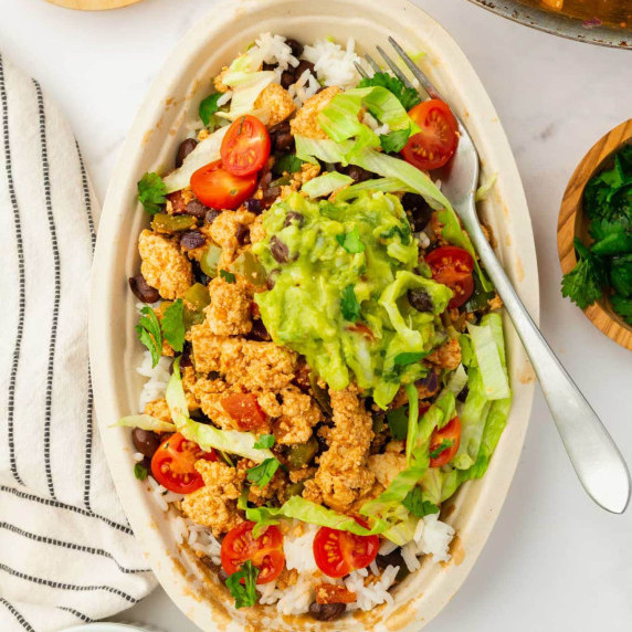 Sofritas in a boat-shaped white bowl with a fork