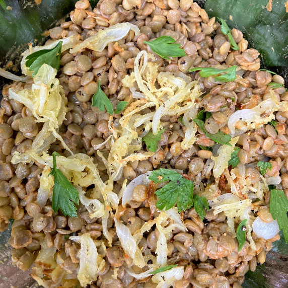 Lentils in a glass bowl with onions and parsley