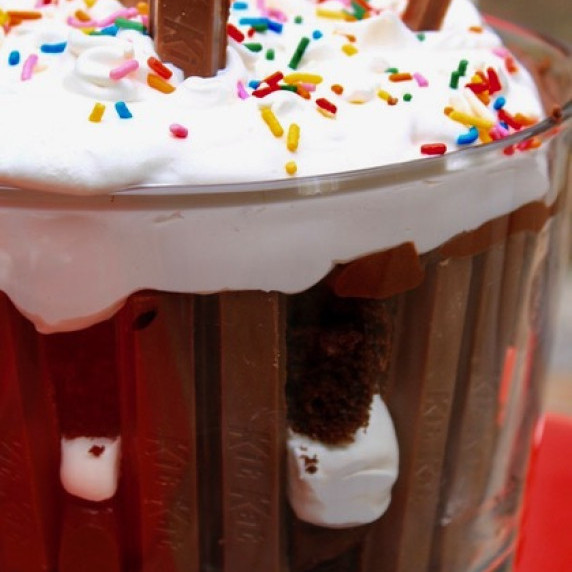 KitKat Trifle arranged in a bowl outside on a red tablecloth.  