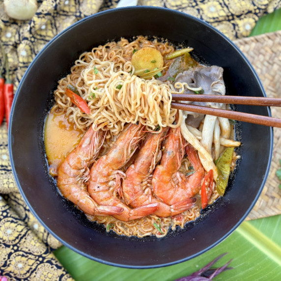 Tom yum instant noodle soup featuring plump shrimp, kaffir lime leaves, mushrooms, and more.