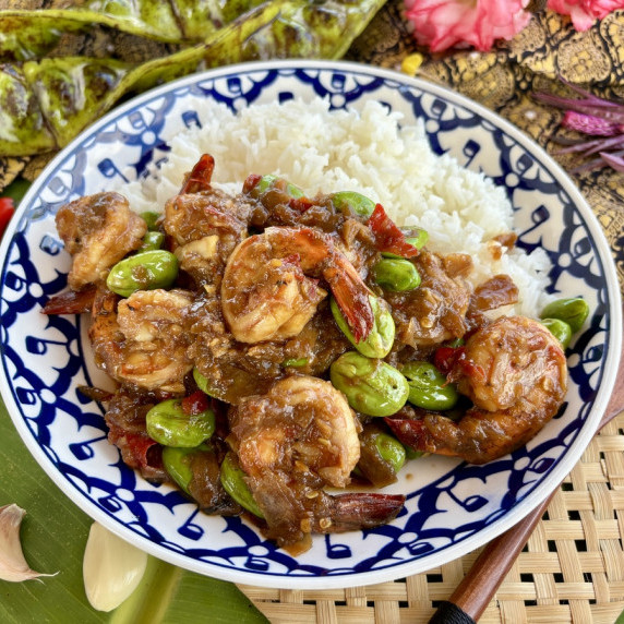 Stink beans stir-fry with shrimp and steamed rice in a patterned dish.