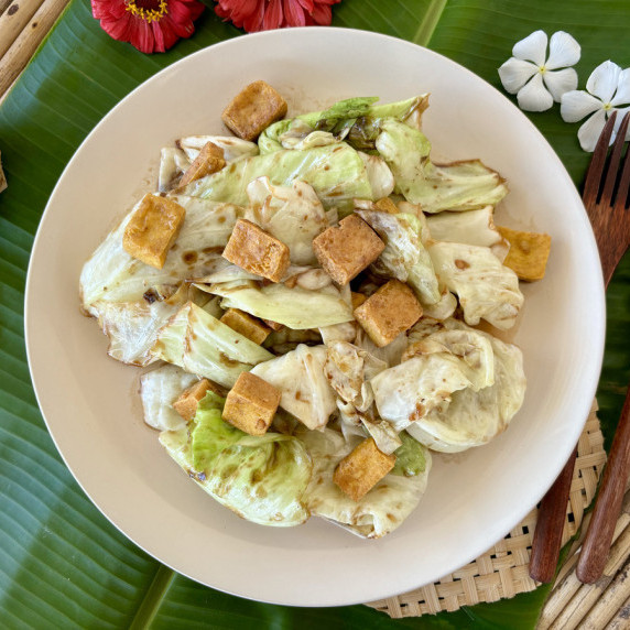 Top-view of vegetarian fried cabbage with tofu in a white dish.