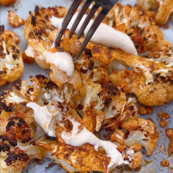 Baked Cauliflower Steaks with Tahini Sauce On A baking tray 