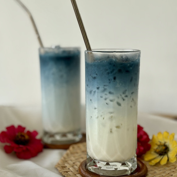 Butterfly pea milk tea, blue milk tea, served in tall glasses.