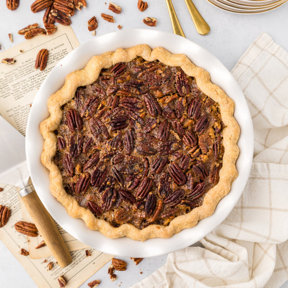 maple pecan pie in a pie dish with pecans 