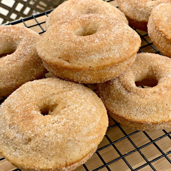 baked cinnamon sugar donuts resting on a wire cooling rack.