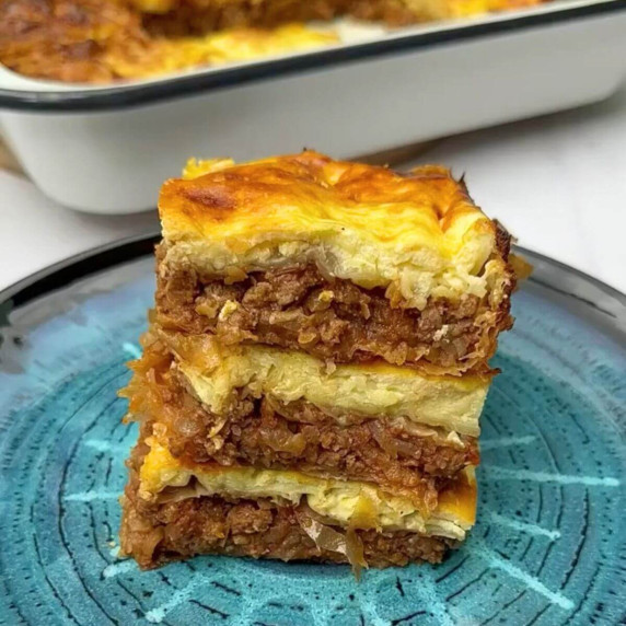 A portion of  Turkish Borek with meat and cheese on a blue plate