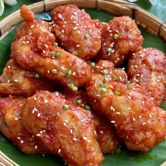 Sweet Thai chili wings with sesame seeds and green onions garnish.