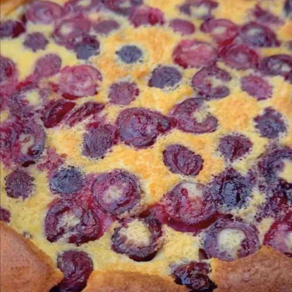 A slice of cherry clafoutis on a white plate