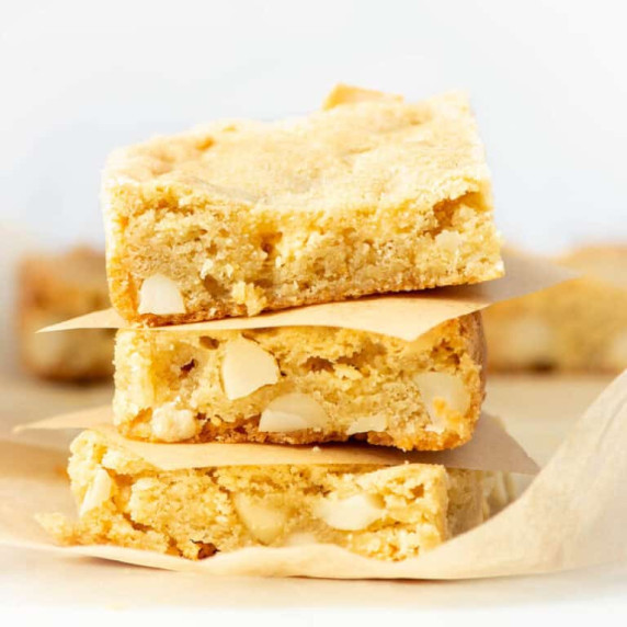 Photo of three stacked white chocolate macadamia nut cookie bars