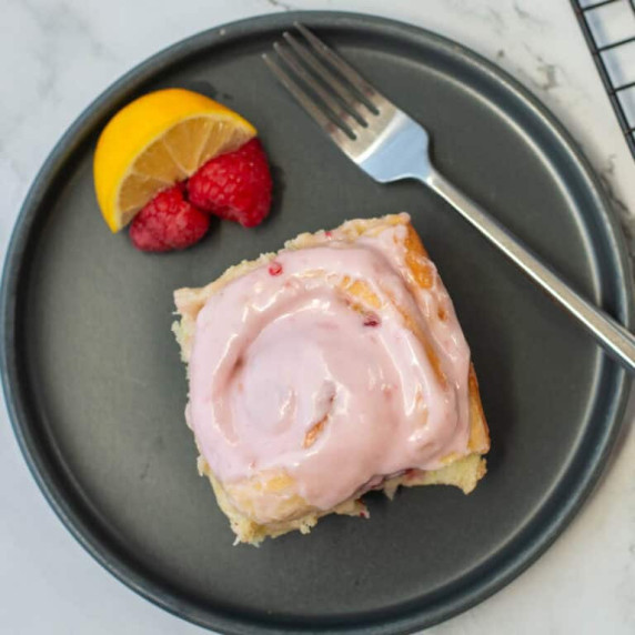 Overhead view of lemon raspberry sweet roll on a plate with a fork