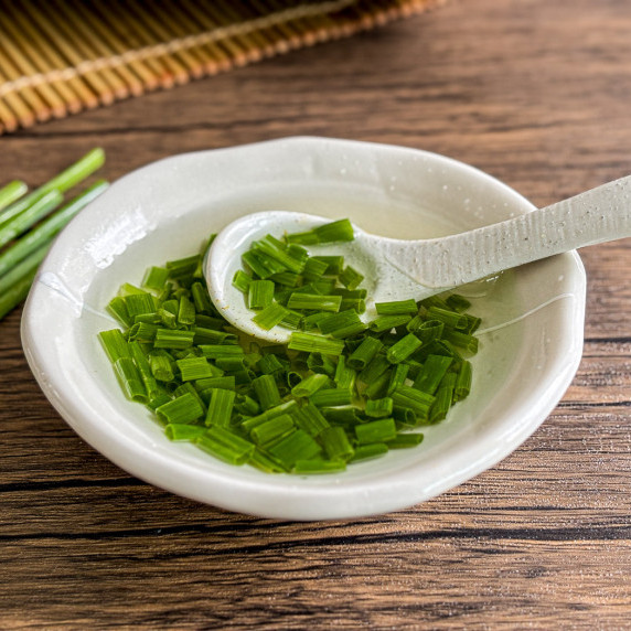 Close-up of mo hanh, Vietnamese scallion oil, in a white bowl.