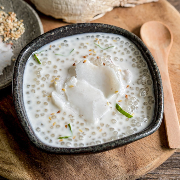 Top-view of Thai coconut tapioca pudding served in a black ceramic dish.