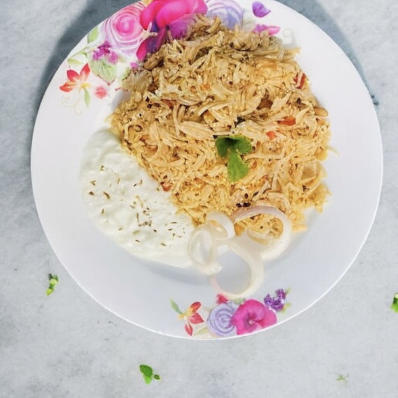 Chana pulao arranged in a floral plate placed on concrete countertop