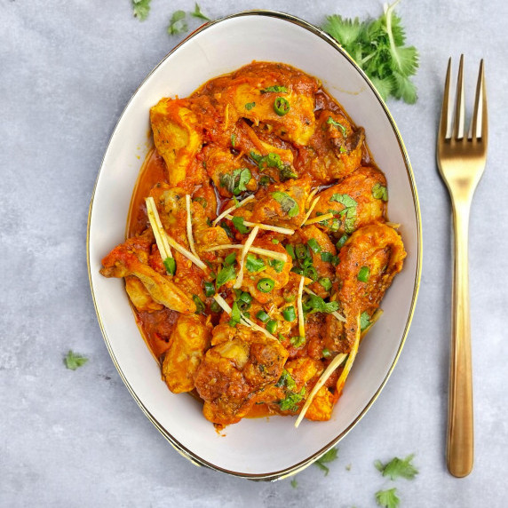 Chicken Karahi arranged in a white dish on concrete countertop 