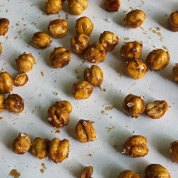 Fried chickpeas covered in salt on a white background