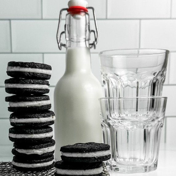 Homemade Oreo cookies with cookies filled with Madagascar vanilla cream stacked neatly with milk 