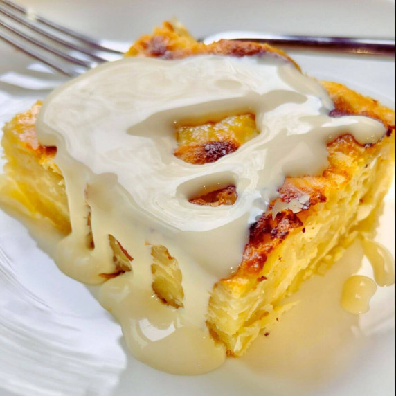 A square of Phyllo Dough Ricotta Crinkle Cake with double cream drizzle 