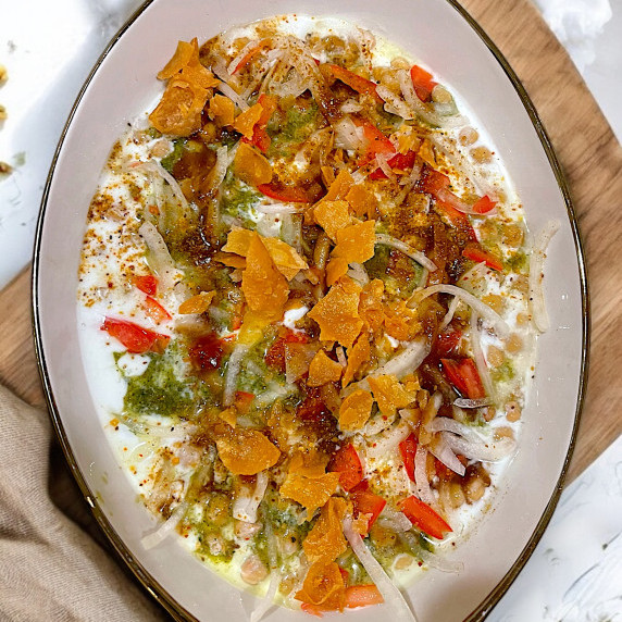 Dahi baray arranged in white dish placed on marble countertop