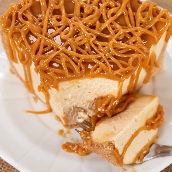 Slice of keto dulce de leche cheesecake with dulce de leche topping.